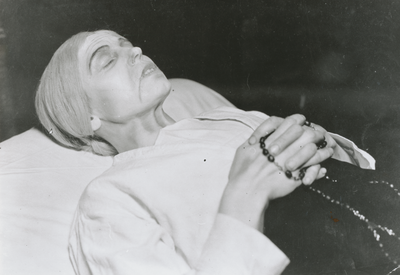 876652 Portret van een gestorven vrouw met een rozenkrans in handen, in een scène uit het toneelstuk 'Het meisje met de ...